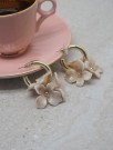 Øredobber med beige blomstercharms thumbnail
